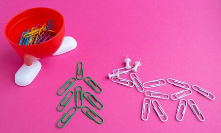Year of the bull 2021.Colorful paper clips isolated on a pink background. Office supplies. Stapling...