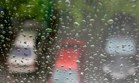 Raindrops on the window, with cars in the Parking lot in the background.の写真素材