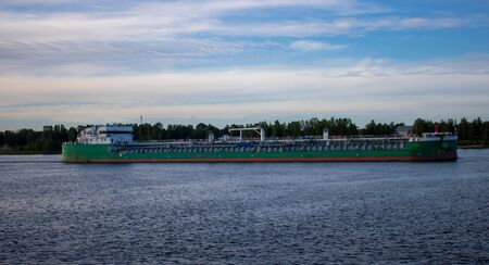 River tanker under the blue sky goes on the river.