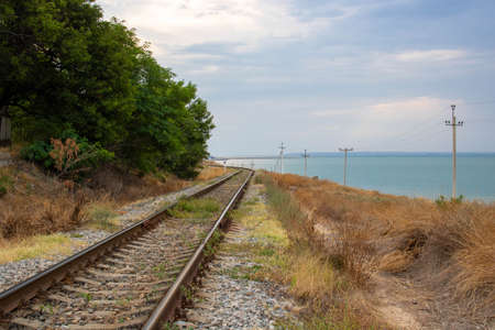 The old railway runs along the coast along the sea.Space for text.の写真素材