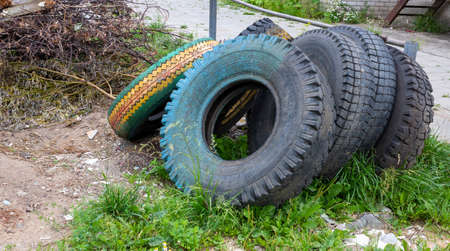 Old dirty tires are lying in the trash. Concept of environment and waste recycling.の写真素材