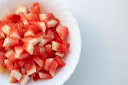 Pieces of watermelon in a white plate on a white background.Space for your text.の写真素材