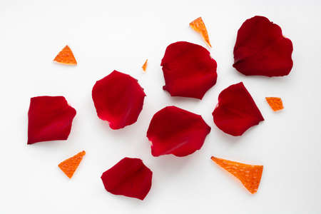 Red rose petals and orange glass shards.の写真素材