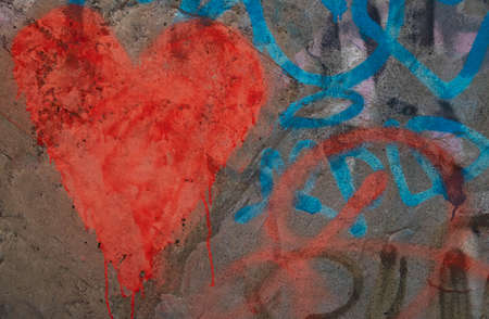 A red heart on a gray concrete wall.