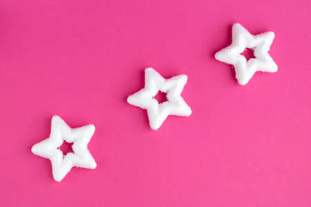 White rough Christmas stars on a pink background.New years concept