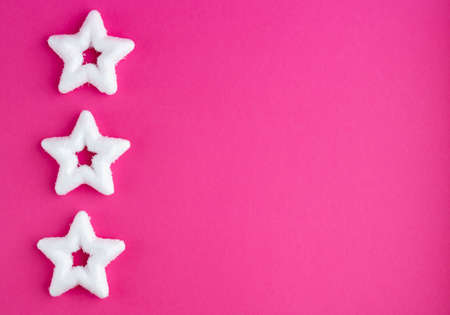 White rough Christmas stars on a pink background. New year's concept.の写真素材