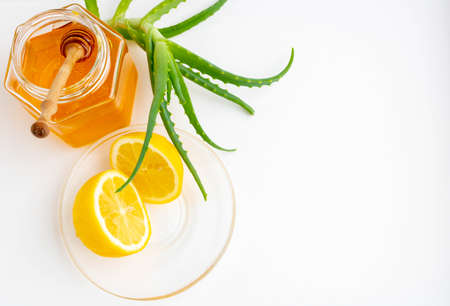 Useful ingredients for strengthening the immune system on a white background.Honey in a jar, lemon and aloe Vera. Space for text.の写真素材