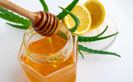 Useful ingredients for strengthening the immune system on a white background.Honey in a jar, lemon and aloe Vera. Space for text.の写真素材