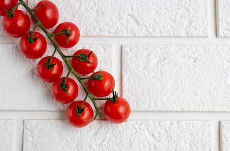 Cherry tomatoes on a branch, isolated on a white background. The view from the top. the concept of crop.の写真素材