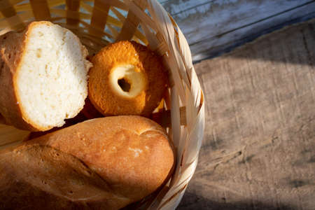 Fresh bread in a basket on a rough wooden table. Food background