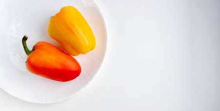Fresh vegetables two orange peppers isolated on a white background. Space for your text.の写真素材