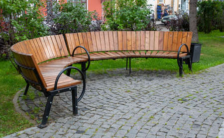 Brown semi-circular bench in the autumn Park.の写真素材