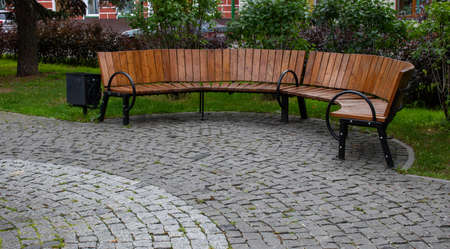 Brown semi-circular bench in the autumn Park.の写真素材