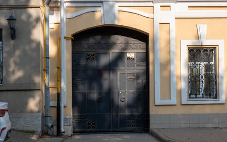 Black iron antique door on the facade of an old house.