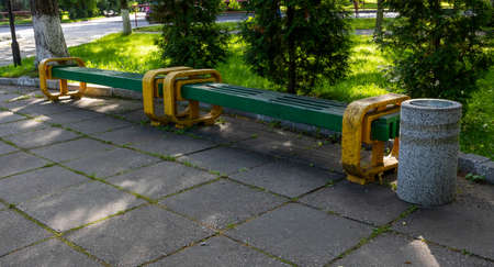 Beautiful Park with a path, original yellow-green bench and urn