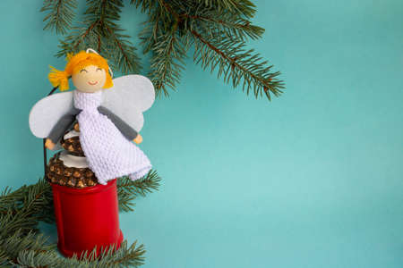 Christmas lantern with fir branches and an angel on a blue background.