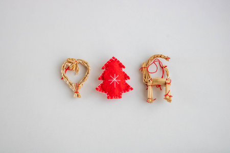 Traditional straw toys and a red Christmas tree on a white background.の写真素材