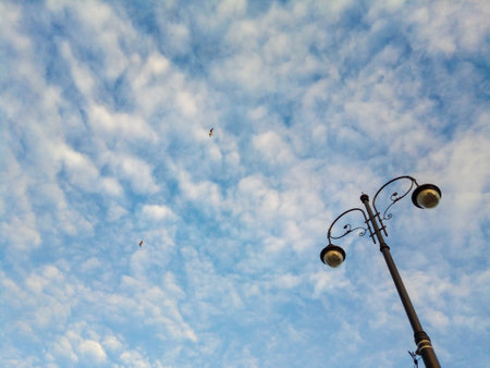 Lantern on a natural blue sky background with beautiful puffy white clouds. Place for your text.の写真素材