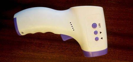 Digital medical infrared frontal thermometer gun  on wooden table