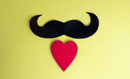 Father's Day concept. Black mustache and red heart on a yellow paper background.の写真素材