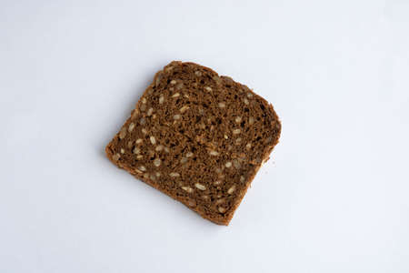 Slice of whole-grain dark bread, isolated on a white background close-up.の写真素材