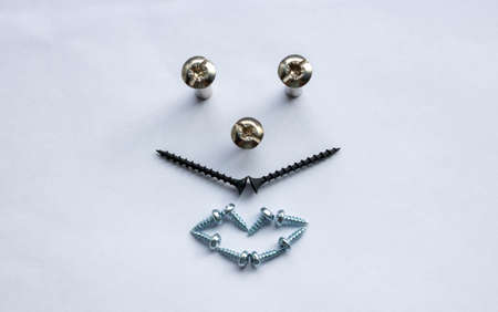 On a white background, a face made of screws and self-tapping screws.Renovation concept, Father's Day.の写真素材