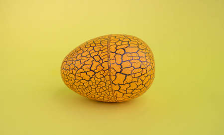 The concept of Easter. Brown spotted egg on a yellow background.の写真素材