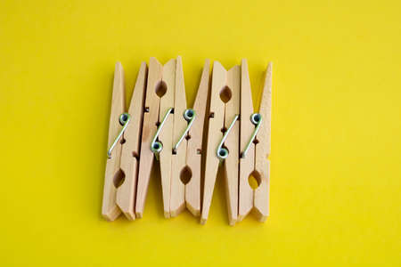 Wooden clothespins for drying clothes on a yellow background.の写真素材