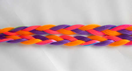 Colored artificial strands of hair. Bright multicolored braids on a white background. Beautiful...