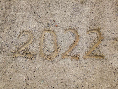 Happy New Year 2022. The symbol of the number 2022 on the sand is a New Year Greeting Card. Copy spaceの写真素材