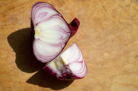 Red sliced onion, isolated on a chopping board.の写真素材
