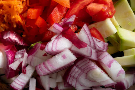 Sliced pieces of red onion, red pepper, zucchini, frying mixture.の写真素材