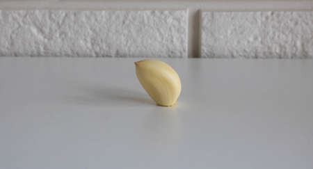 Garlic clove isolated on a white kitchen table background.