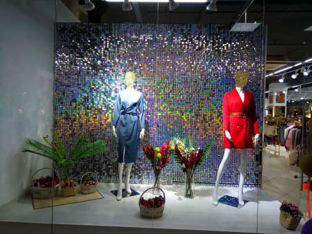 Mannequins behind a shop window on a sparkling background.