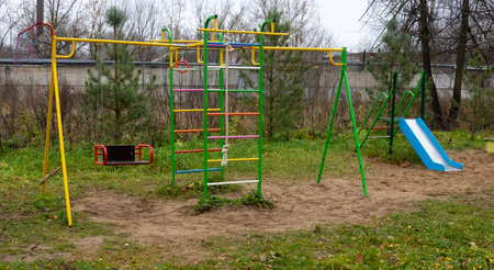 Empty swing on the playground in the yard. An empty place during the coronavirus pandemic.
