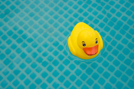 A bright yellow toy duck in the pool is a relaxation concept. With space for your text.の写真素材