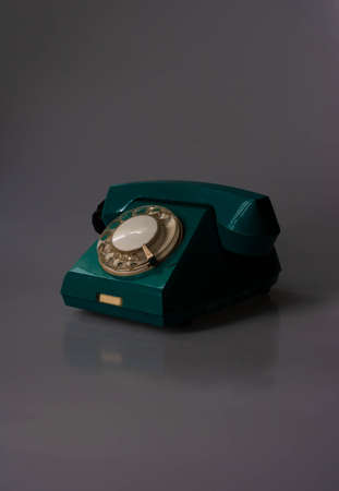 Retro swivel green phone on dark background.