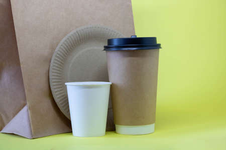 Eco-friendly containers, a paper food bag on a yellow background. Without plastic. Takeaway food....