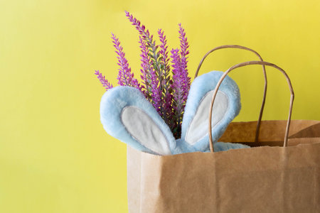 A bandage, blue rabbit ears and an artificial lavender branch stick out of the package. Easter...