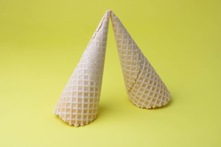 Creative photo of empty waffle cones on a yellow background.の写真素材