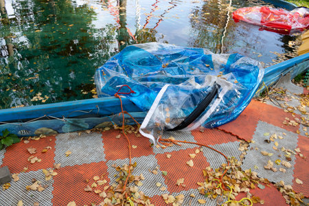 A deflated balloon for an attraction in the water. Dirty water surface in the pool, autumn leaves floating on the water.の写真素材