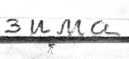 The word winter is written in Russian letters on the white snowの写真素材