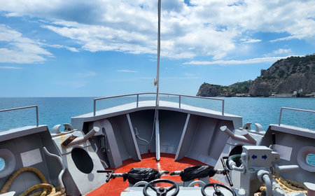 The bow of a pleasure boat on the right is a mountainous shoreの写真素材