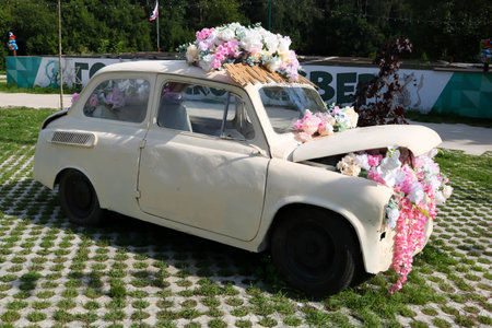 An old white flower bed car stands on the lawn on a bright spring dayの写真素材