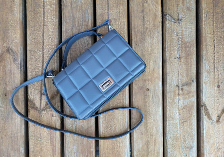 A brown handbag on a wooden deck on a bright sunny dayの写真素材