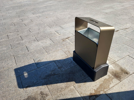 Shiny rectangular metal urn on a city street on a clear sunny day.の写真素材