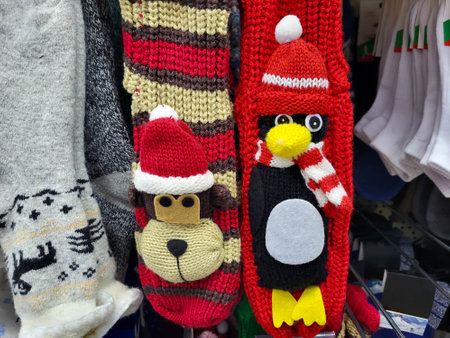 Funny Christmas knitted socks with a penguin and a dog's face in Santa Claus hats are hanging in the shop window.の写真素材