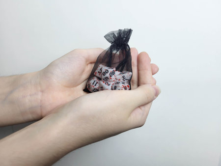 His hands are holding a black transparent bag with cubes. Table games. Holiday leisureの写真素材