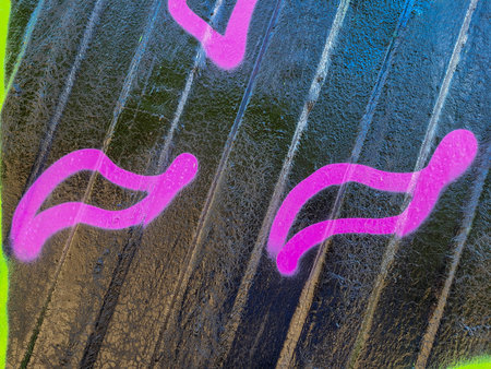 A black painted iron fence with pink stripes.の写真素材