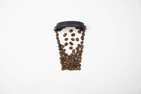 A plastic lid and coffee beans arranged in the shape of a cup on a white background. The concept of...